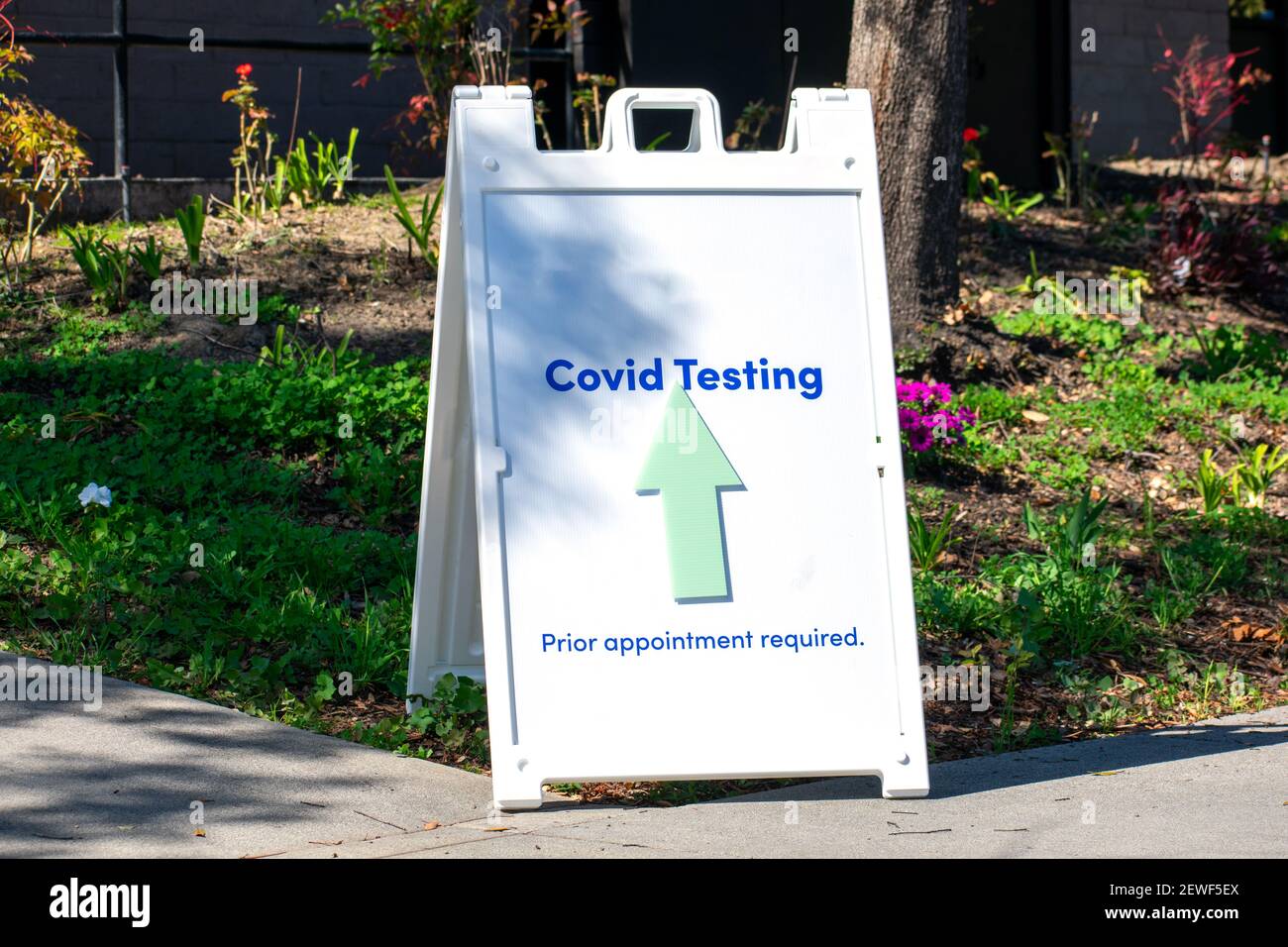 Test Covid, previo appuntamento obbligatorio con un cartello con una freccia indirizza i visitatori al centro di test del coronavirus. Foto Stock