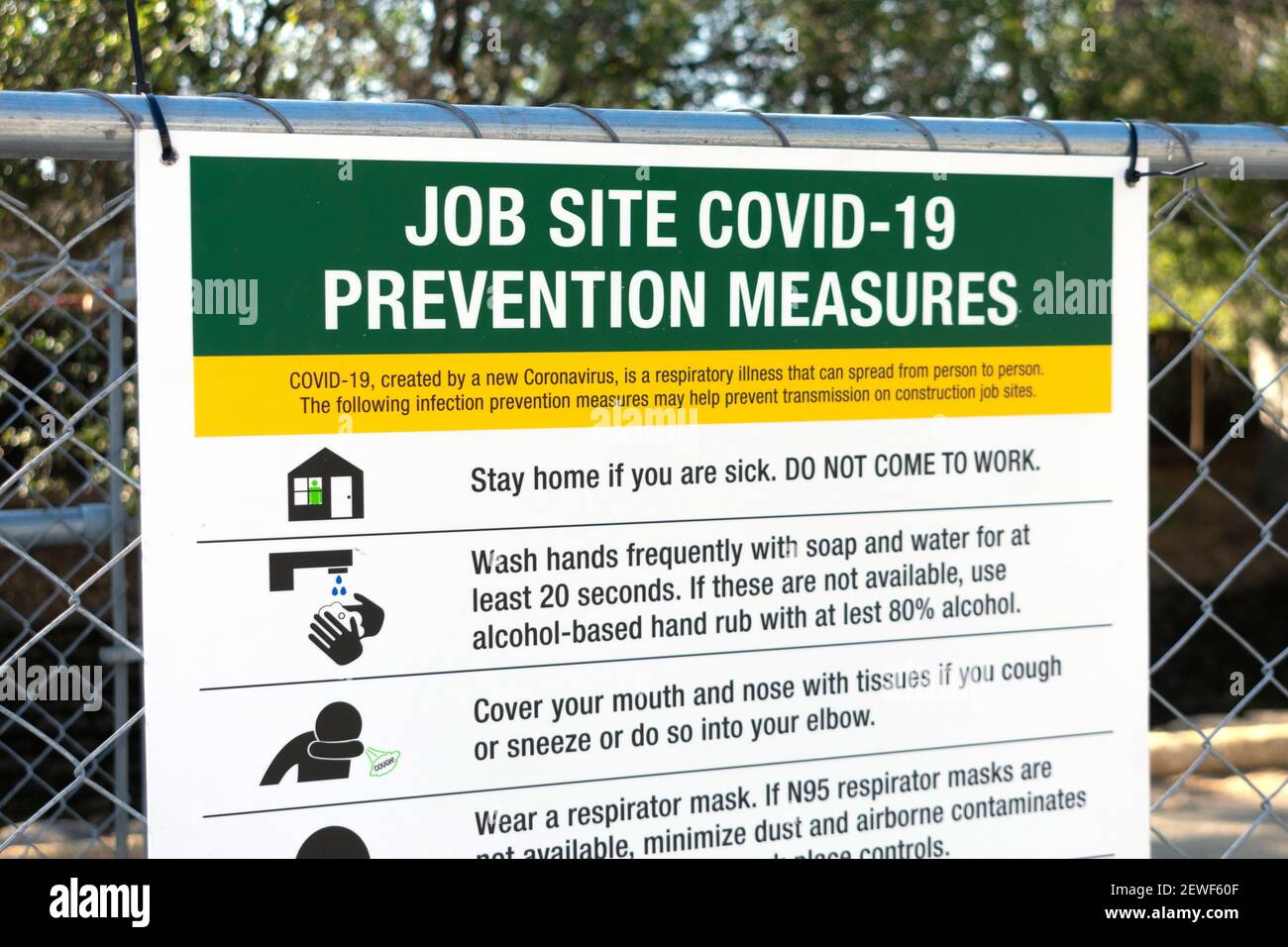 Cartello delle misure di prevenzione del cantiere Covid-19 con le istruzioni appese sulla recinzione all'ingresso del luogo di lavoro. - San Jose, California, Stati Uniti d'America - 2021 Foto Stock
