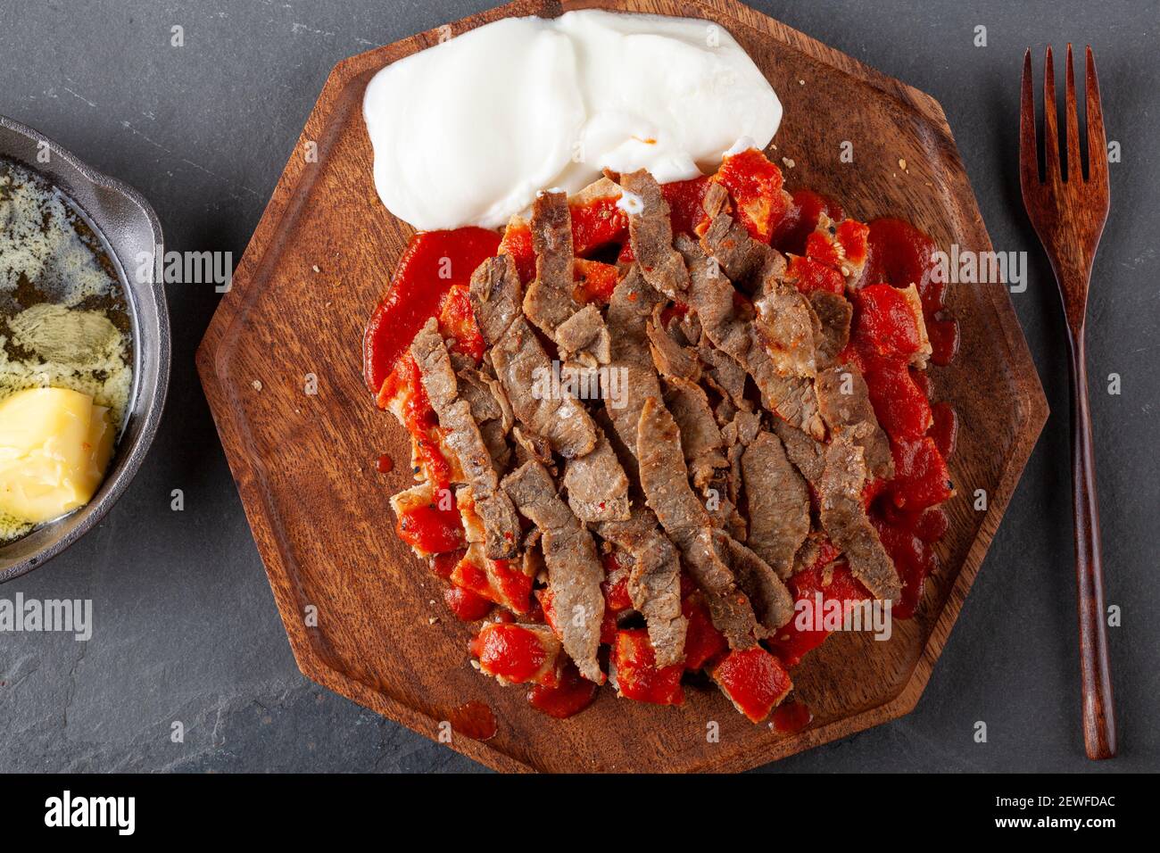 Tradizionale donatore turco kebab (shawarma) fatto con carne di agnello tagliata alla griglia al carbone, servita su pezzetti di pane piatto turco con salsa di pomodoro. A ca Foto Stock