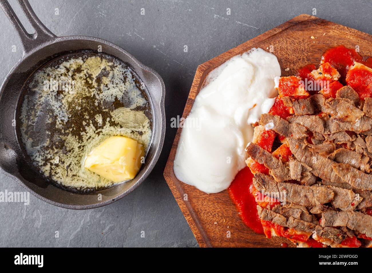 Tradizionale donatore turco kebab (shawarma) fatto con carne di agnello tagliata alla griglia al carbone, servita su pezzetti di pane piatto turco con salsa di pomodoro. A ca Foto Stock