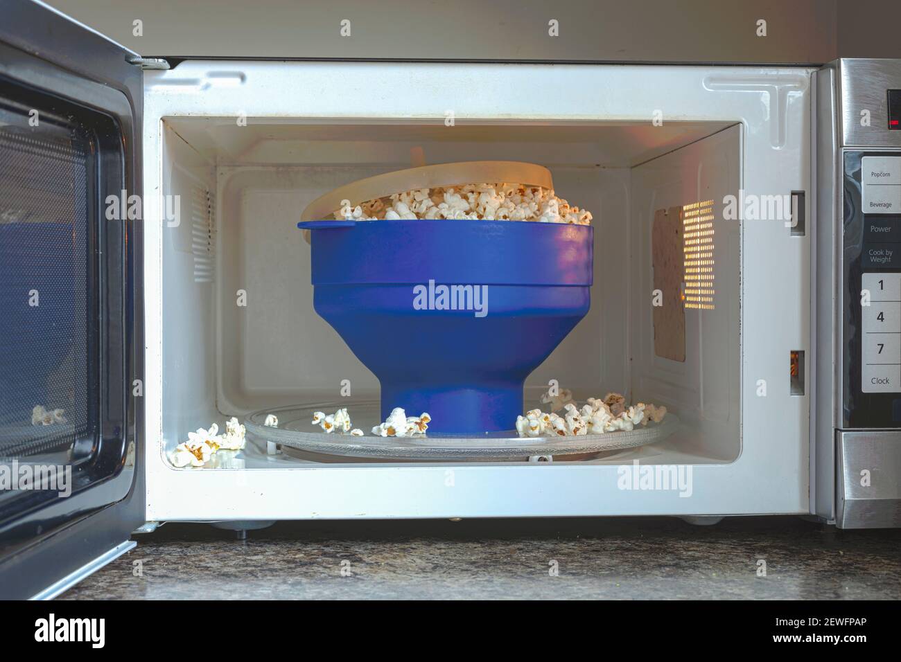 Popcorn fatti in casa privi di grassi e sale in un recipiente per popcorn pieghevole privo di BPA in silicone all'interno del microonde. Questa ciotola offre gilt schiocchi istantanei liberi Foto Stock