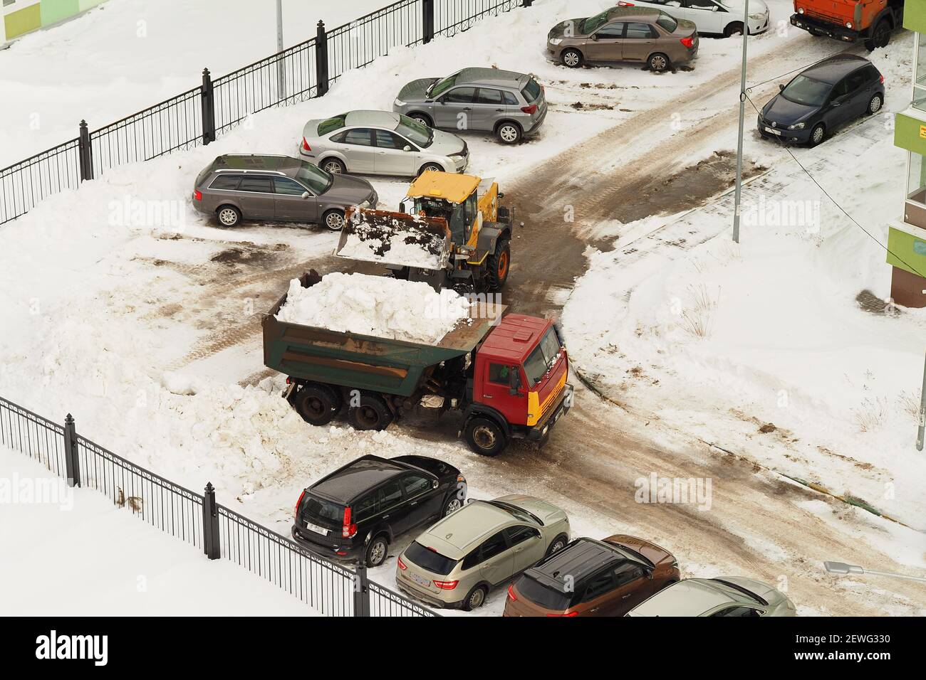 Attrezzatura per la rimozione della neve. Pulizia di strade e iarde dalla neve. Un autocarro a scarico carica la neve in un truc Foto Stock