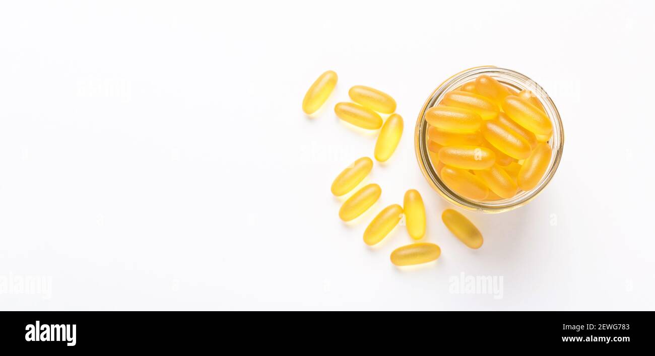 Omega 3 capsule in vaso di vetro su sfondo bianco olio di pesce softgels gialli Vitamina D, e, UN supplemento concetto di banner di sanità Copia spazio Foto Stock