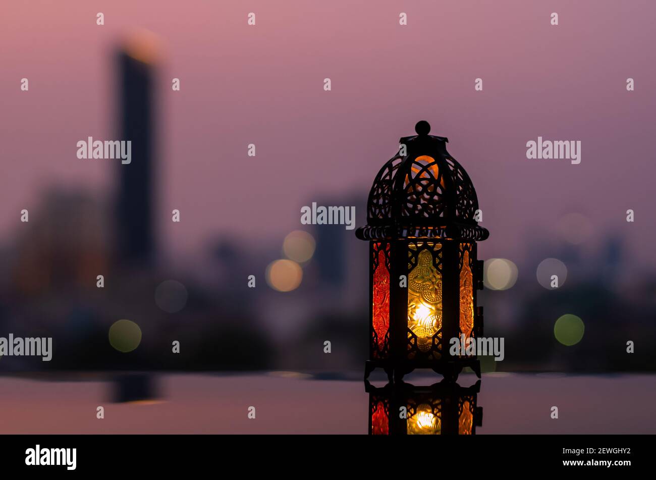 Lanterna con cielo all'alba e città bokeh sfondo luminoso per la festa musulmana del mese santo di Ramadan Kareem. Foto Stock