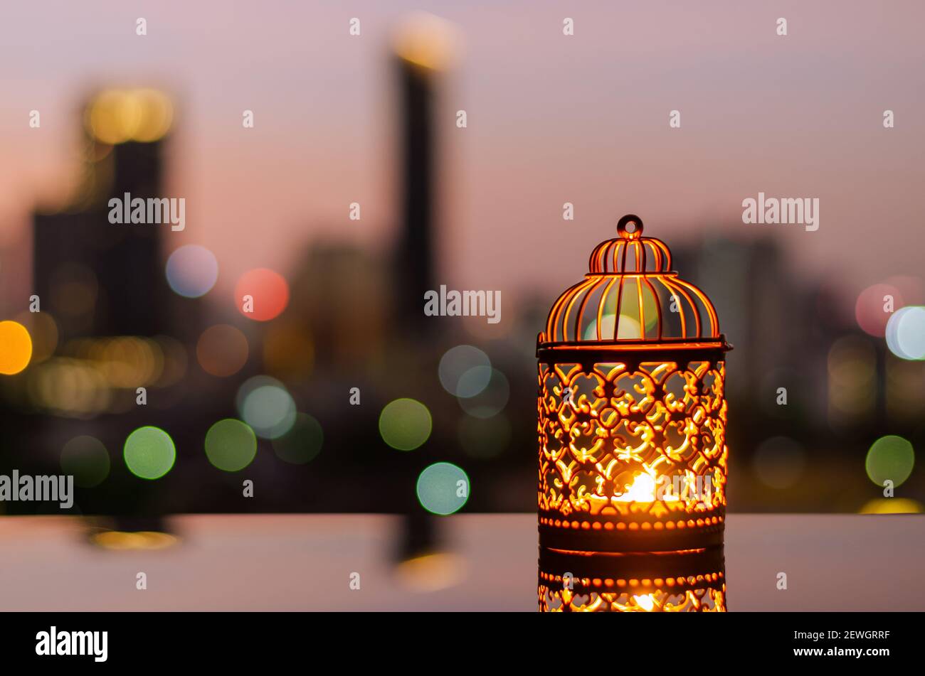Lanterne d'oro con cielo all'alba e sfondo chiaro bokeh della città per la festa musulmana del mese santo di Ramadan Kareem. Foto Stock