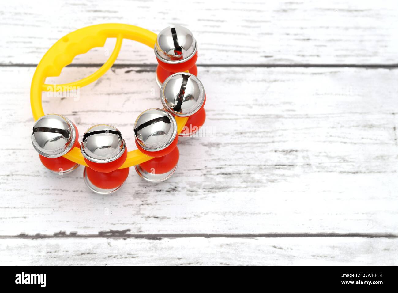 campana colorata di jingle su un tavolo di legno bianco Foto Stock