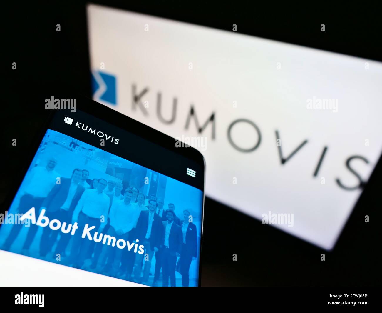 Telefono cellulare con pagina web della società tedesca di stampa 3D Kumovis GmbH su schermo davanti al logo aziendale. Mettere a fuoco in alto a sinistra del display del cellulare. Foto Stock