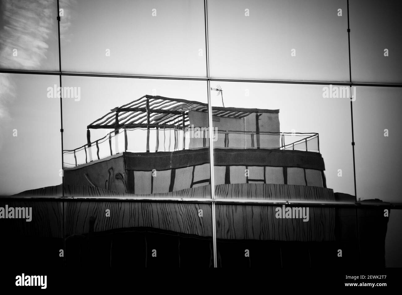 Riflessi del vecchio edificio sul tetto in moderne finestre dell'edificio di uffici in vetro. Foto Stock