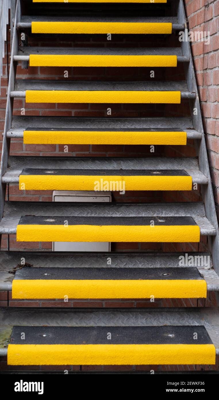 Esterno, scala in metallo con gradini antiscivolo gialli a Westbury, Wiltshire, Inghilterra, Regno Unito. Foto Stock