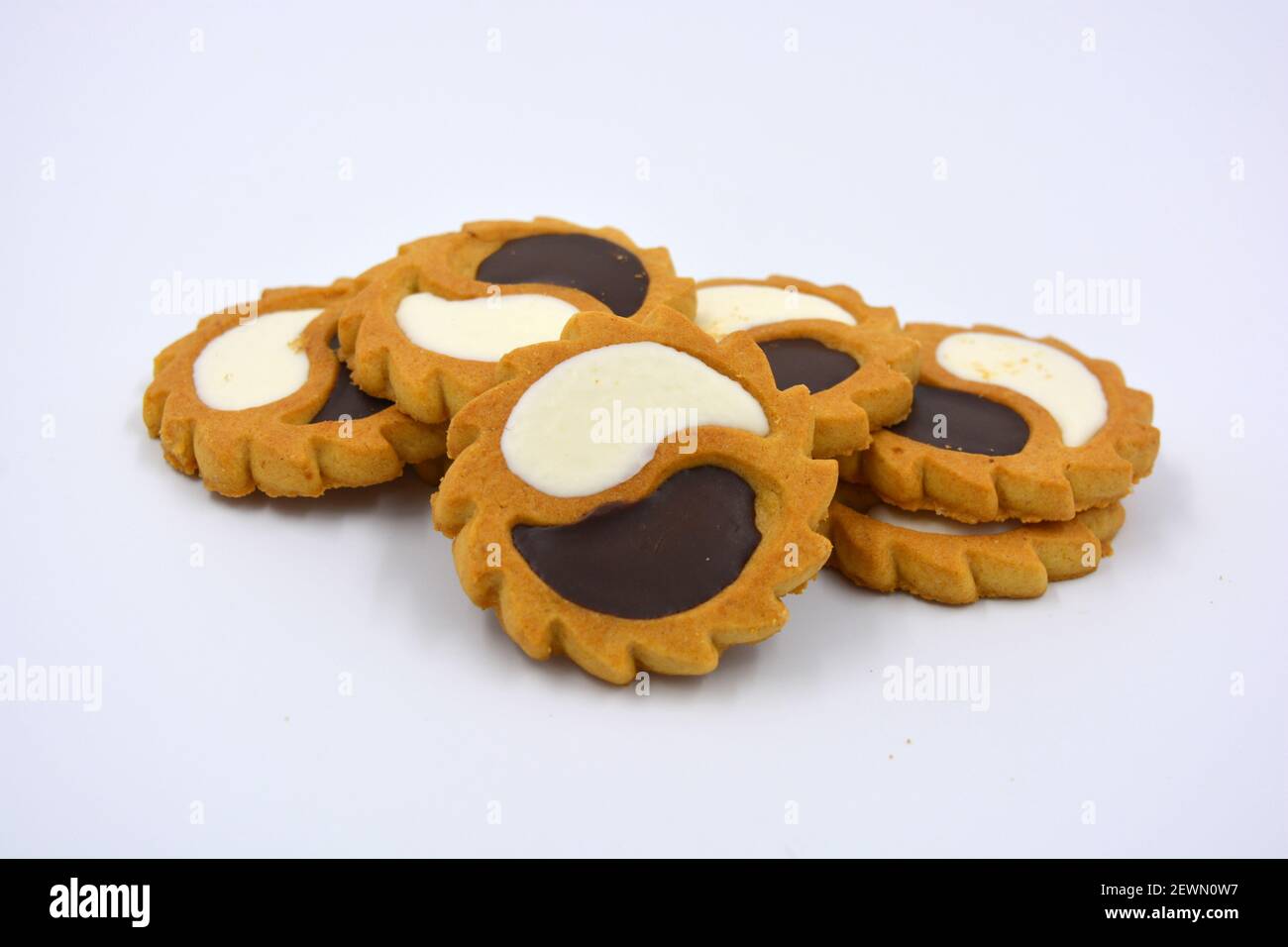 Biscotto di sicurezza sotto forma di sole con stucco bianco e cioccolato, dolce sotto forma di due gocce poste su fondo bianco. Foto Stock