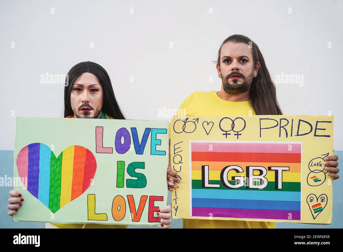 Drag regine con banner lgbt all'aperto per protesta d'orgoglio - Mettere a fuoco i volti Foto Stock