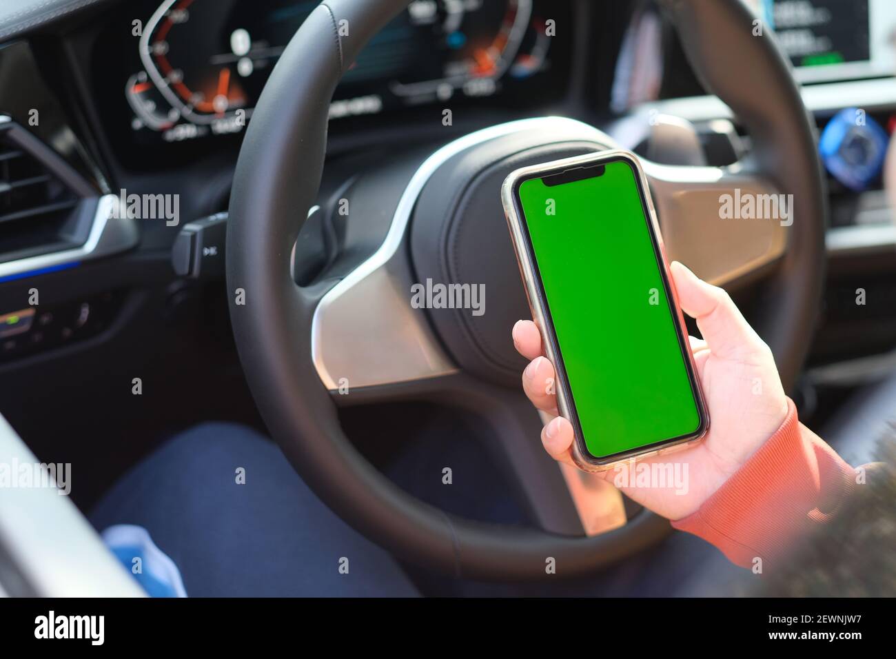 vista sulla spalla dello schermo verde intelligente che tiene la mano telefono in auto Foto Stock