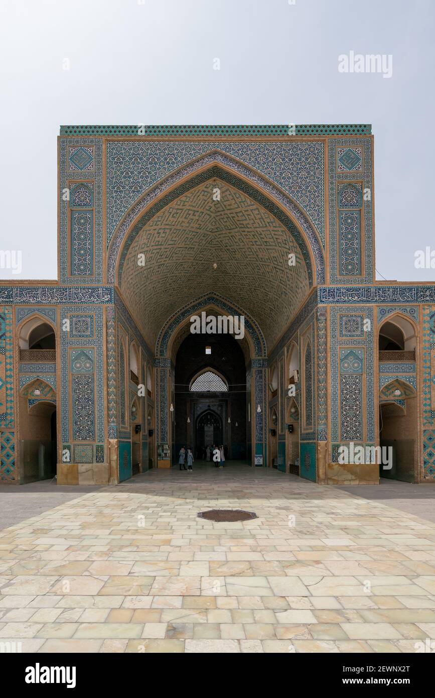 Yazd, Iran - 13.04.2019: Cortile della storica Moschea Jameh di Yazd con le sue piastrelle esagonali e turchesi. Persone che camminano nel cortile di Shia Foto Stock