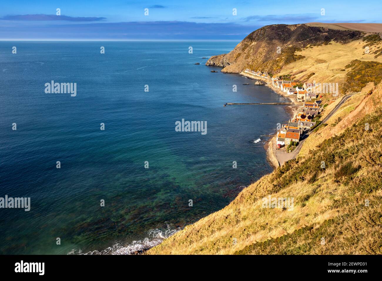 CROVIE VILLAGGIO ABERDEENSHIRE SCOZIA LA FILA DI CASE E CHIARO ACQUA DI MARE VERDE DELLA BAIA Foto Stock