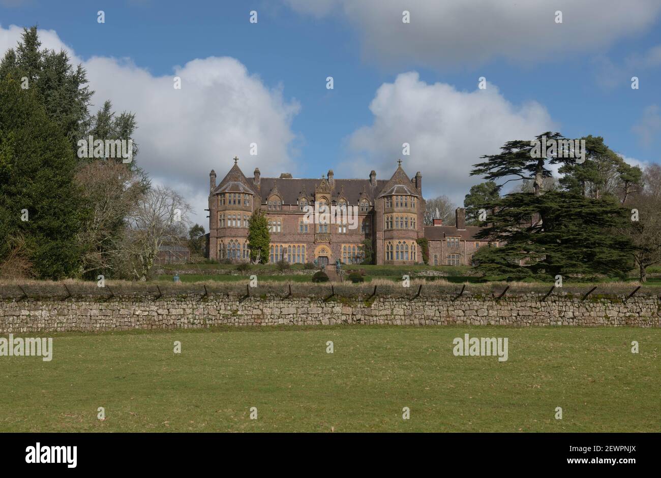 Victorian Gothic Mansion situato a Parkland a Knightshayes in un luminoso giorno invernale nella campagna rurale del Devon, Inghilterra, Regno Unito Foto Stock