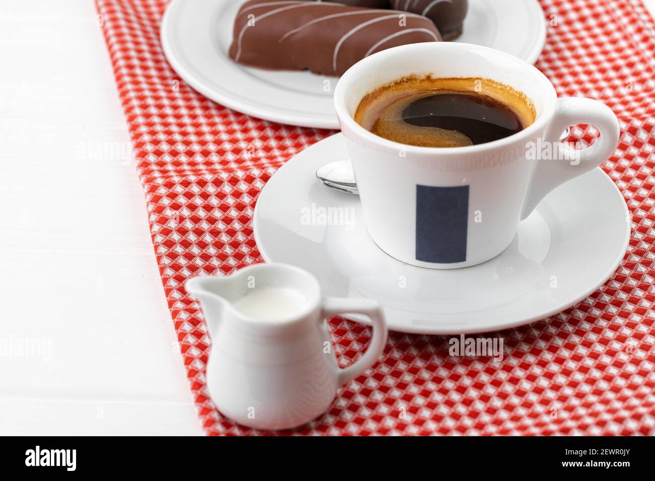 Tazza di caffè e piattino con dolci al cioccolato su legno tabella Foto Stock
