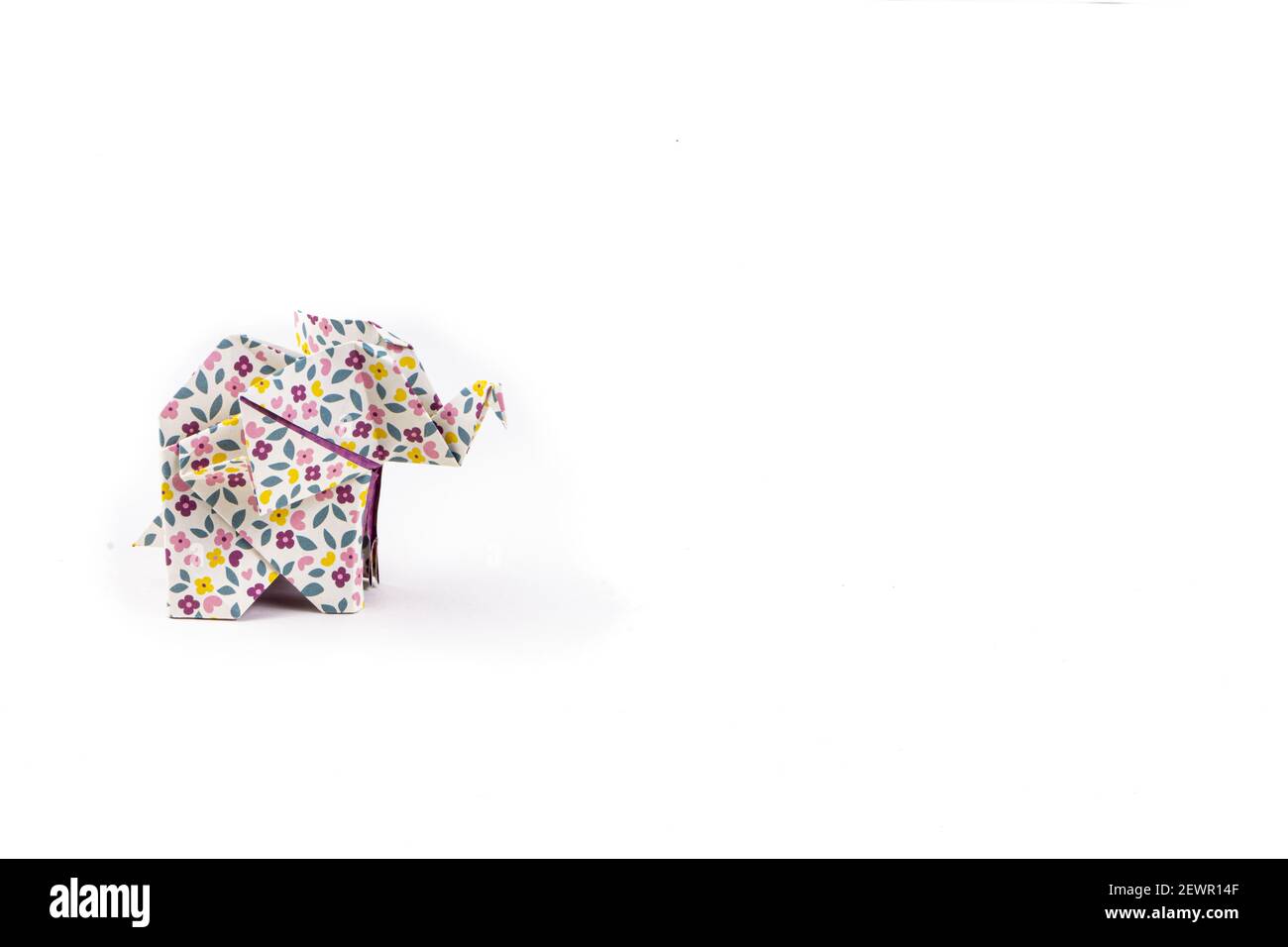 Un primo piano di un elefante origami con motivi floreali isolato sopra uno sfondo bianco Foto Stock