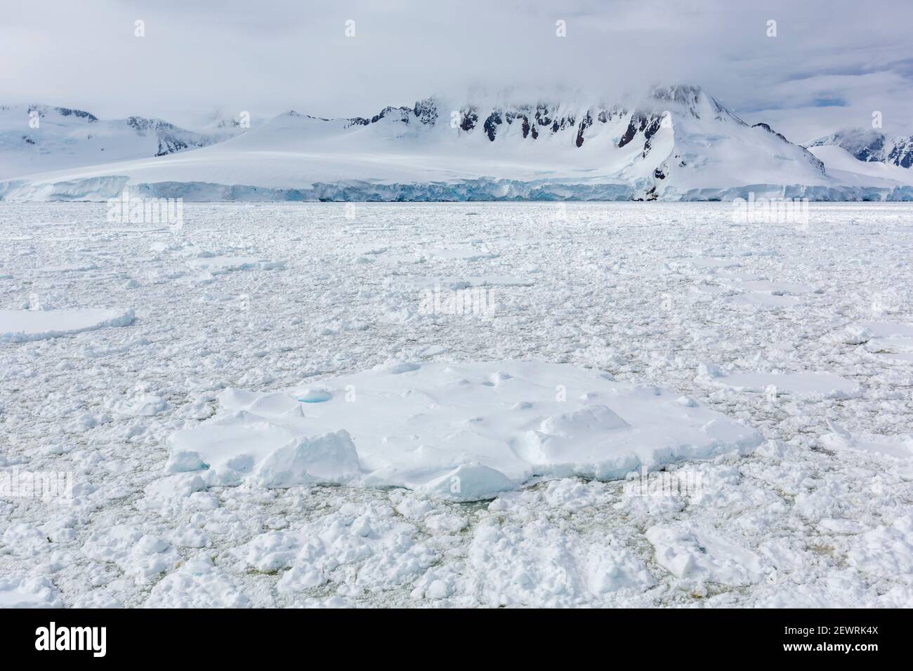 Montagne innevate e fitti ghiacci marini nel canale di Neumayer, nell'Arcipelago di Palmer, in Antartide, nelle regioni polari Foto Stock