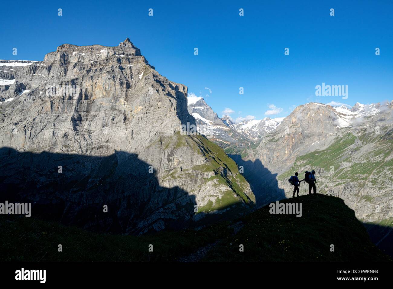 Due escursionisti che ammirano le montagne durante l'escursione verso il Rifugio Muttsee sul sentiero Kalktrittli, Canton Glarona, Svizzera, Europa Foto Stock