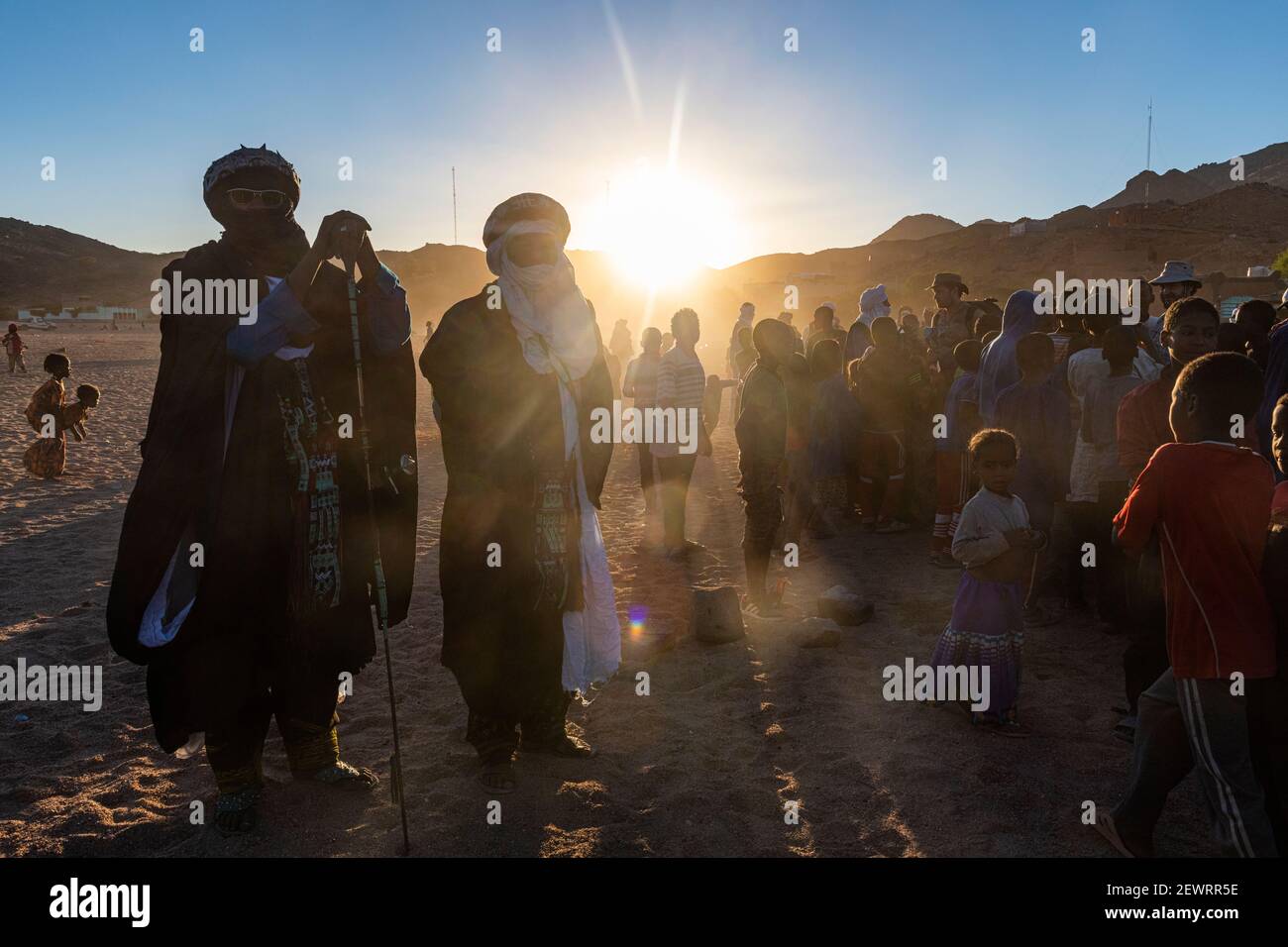 Retroilluminazione di una folla di bambini e uomini Tuareg, Oasi di Timia, Air Mountains, Niger, Africa Foto Stock