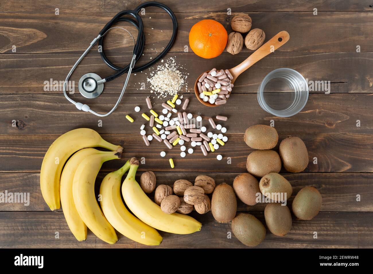 Alcune sostanze nutritive, frutta e medicine per prendersi cura del cibo su uno sfondo di legno scuro. Concetto di stile di vita sano. Foto Stock