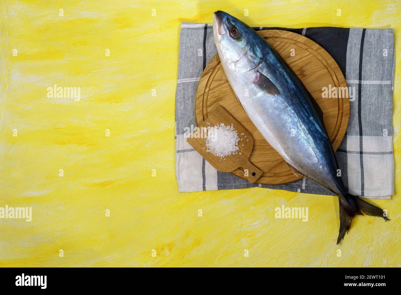 La lacedra dalla coda gialla è una specie di pesce alettato a raggi marini della famiglia Carangidae, su sfondo giallo Foto Stock