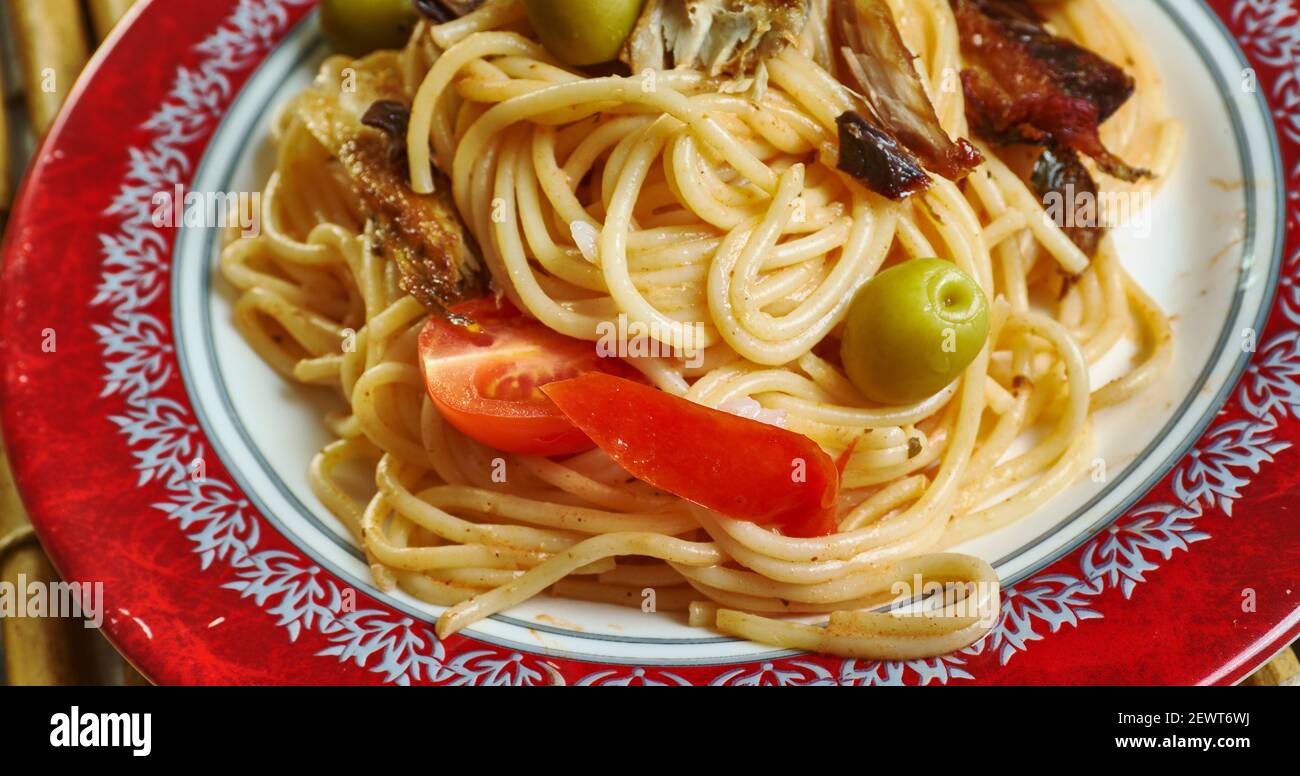 Spaghetti alla salsa con sardine aggiungere i peperoncini, i pomodori. Foto Stock