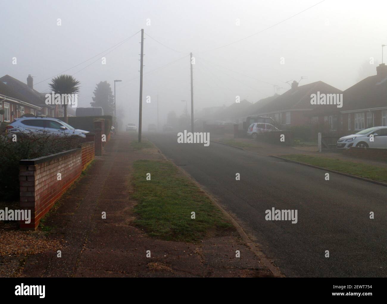 La mattina presto nebbia e nebbia in una zona residenziale nel distretto suburbano di Hellesdon, vicino Norwich, Norfolk, Inghilterra, Regno Unito. Foto Stock