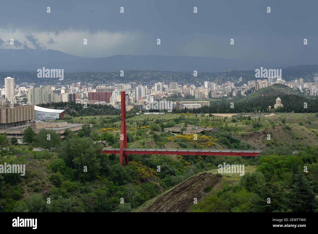 Splendida vista panoramica di Tbilisi, Georgia, sotto la tempesta piovana in avvicinamento, con passerella pedonale sopra la gola che domina il colpo Foto Stock