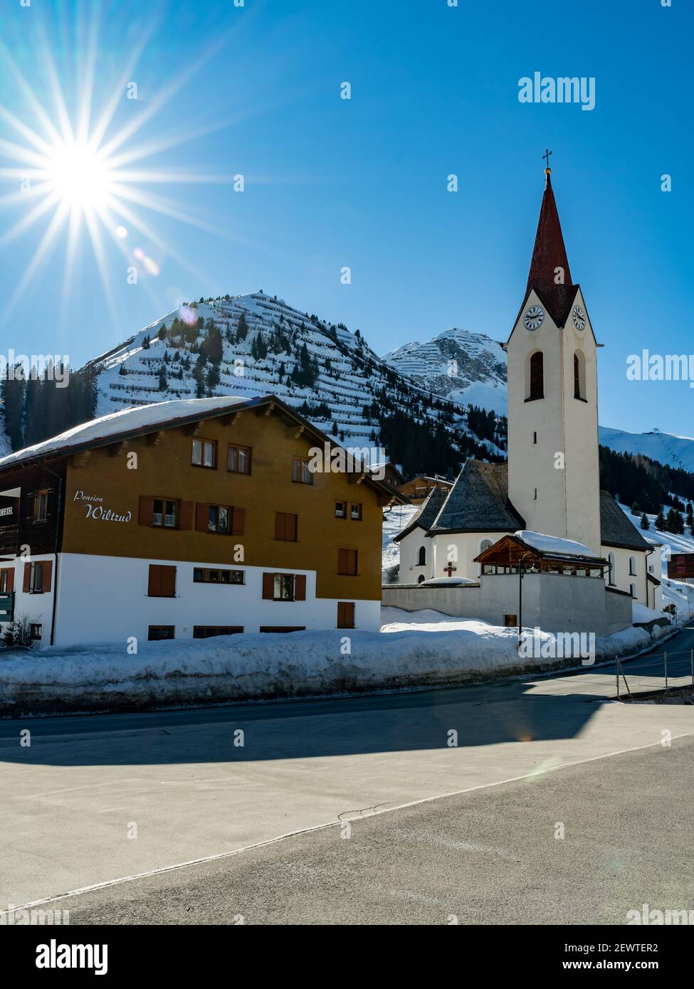 chiesa di Warth, Bregenzerwald con la montagna Karhorn sullo sfondo. Paese delle meraviglie invernali e meta di vacanza per sci e racchette da neve Foto Stock