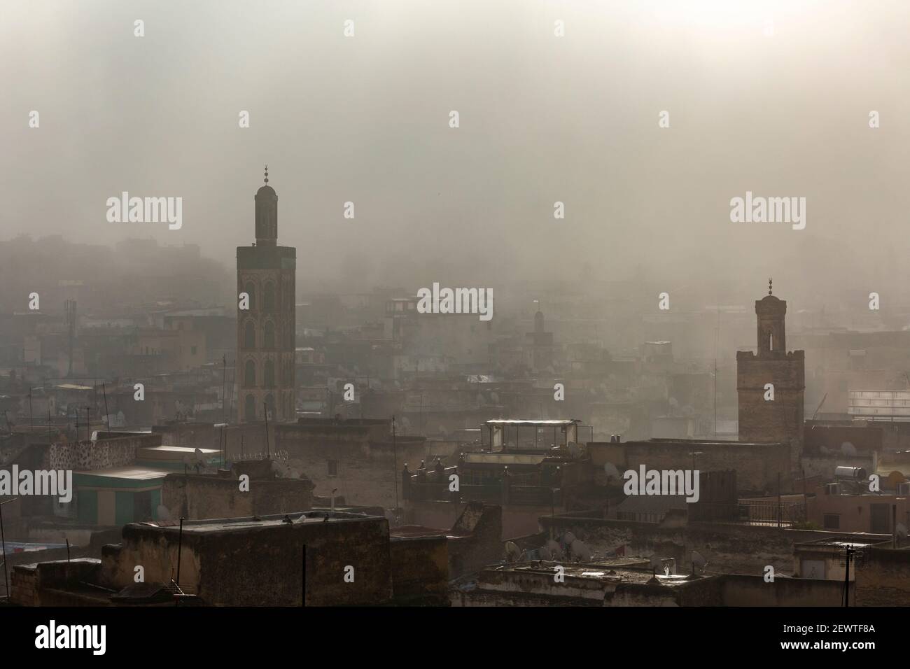 Vista dal paesaggio urbano della medina di Fes che mostra i minareti durante un'alba foggy, come visto da Riad Laayoun, Fes, Marocco Foto Stock