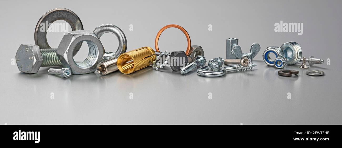 Diversi tipi di bulloni metallici, dadi, viti, ganci e rondelle. Dispositivi di fissaggio e attrezzi hardware sul tavolo. Foto Stock