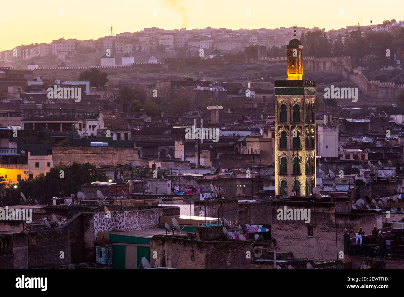 Vista sulla città della medina di Fes con minareto illuminato appena prima dell'alba, come visto da Riad Laayoyn, Fes, Marocco Foto Stock