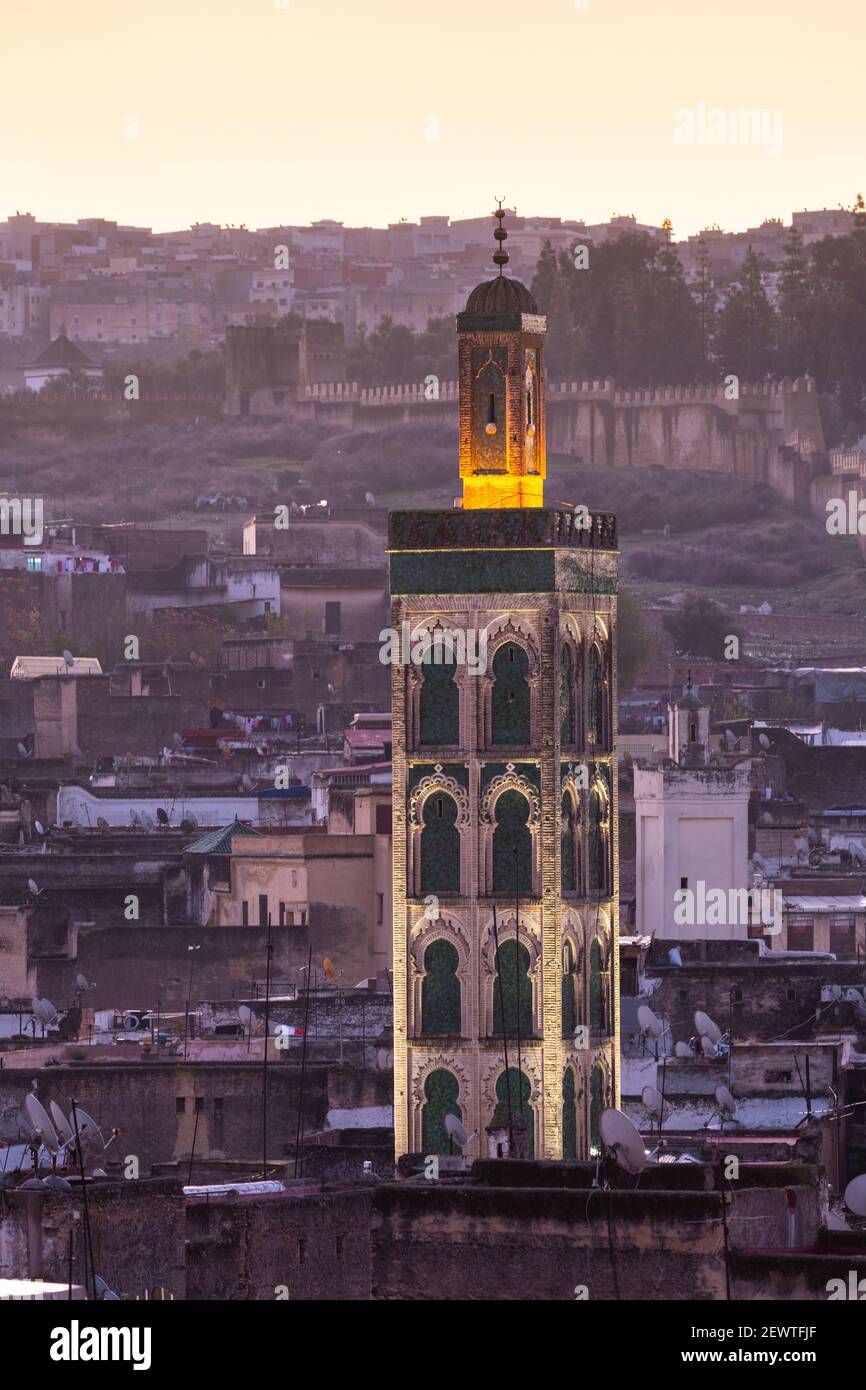 Vista sulla città della medina di Fes con minareto illuminato appena prima dell'alba, come visto da Riad Laayoyn, Fes, Marocco Foto Stock