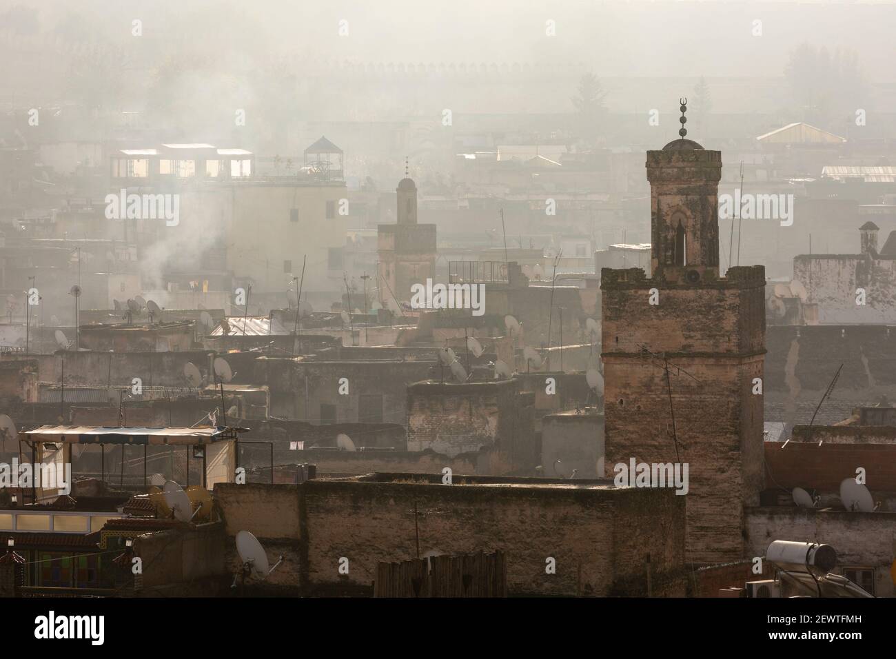 Vista della città della medina di Fes con minareti durante un'alba foggosa, come visto da Riad Laayou, Fes, Marocco Foto Stock
