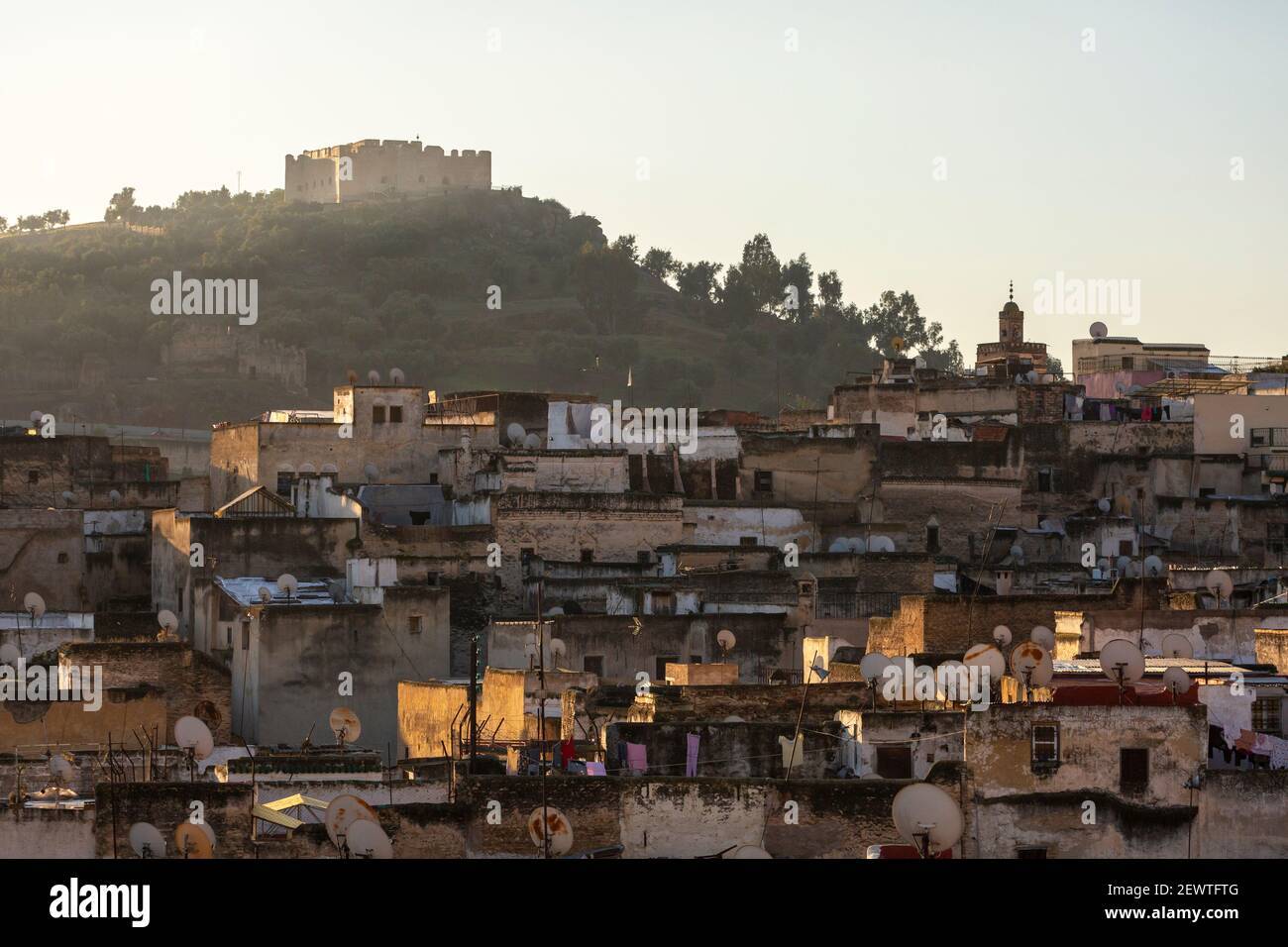 Vista panoramica sui tetti della medina Fes con il forte Borj Sud in cima alla collina sullo sfondo, Fes, Marocco Foto Stock