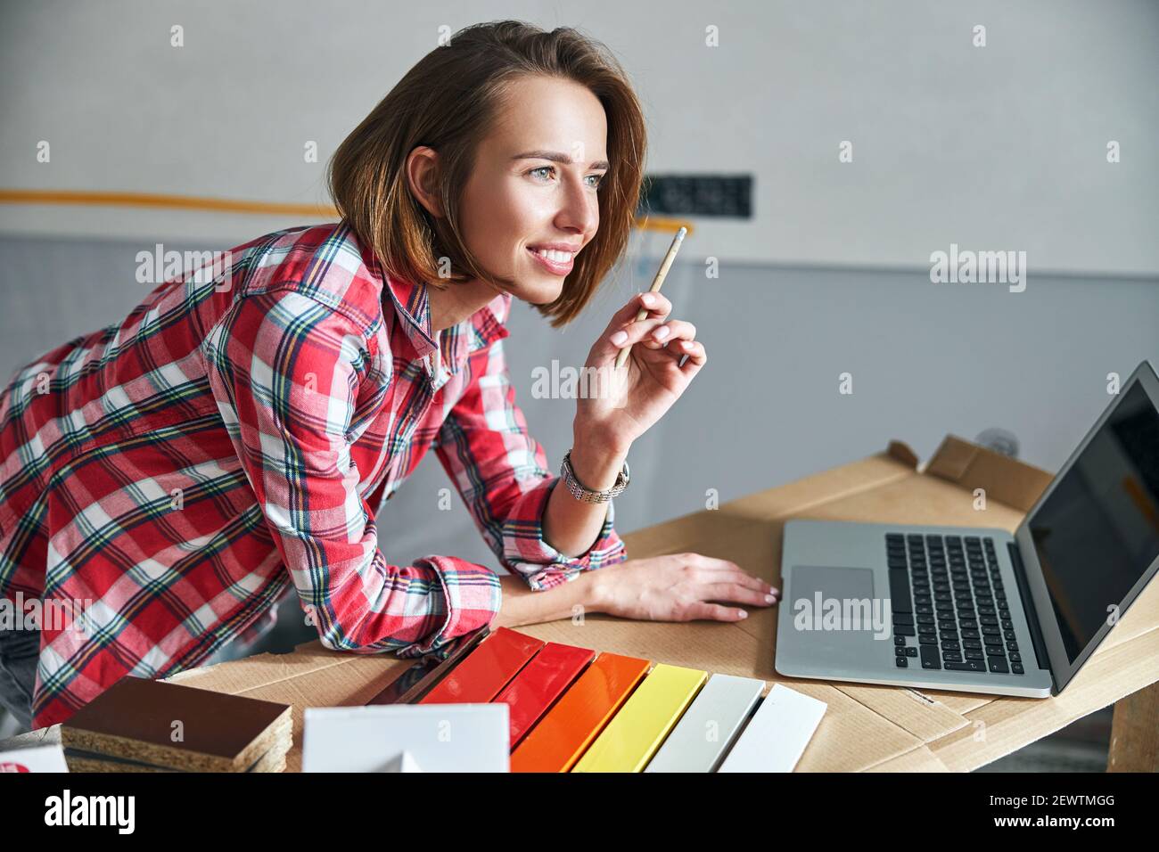 Sorridente interior designer perso in riverbero sul posto di lavoro Foto Stock