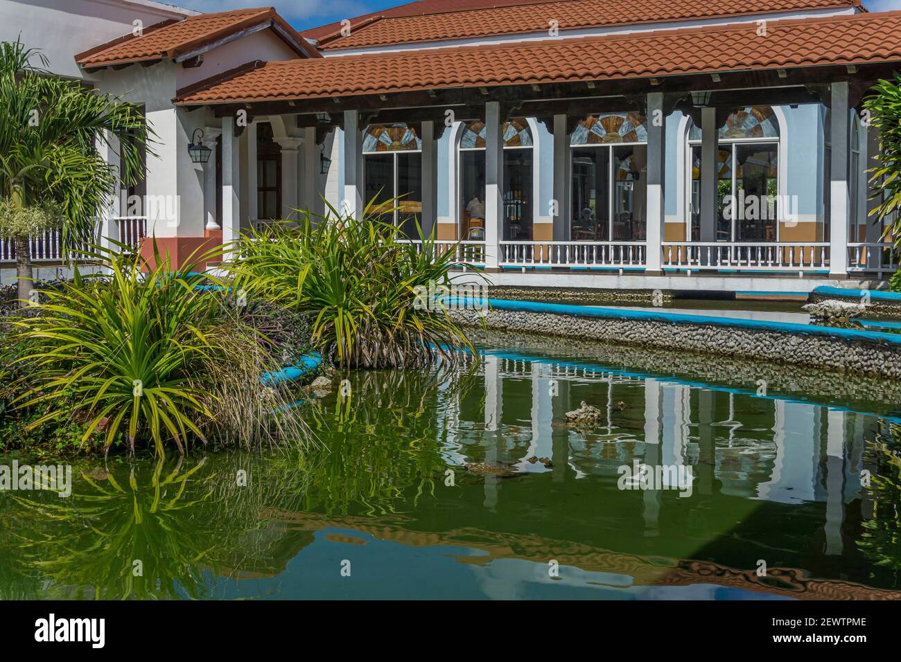 Cayo Santa Clara, Cuba, 2016 febbraio - Ristorante con tetto in tegole Clay con riflessione in un stagno artificiale con canne in un resort alberghiero Foto Stock