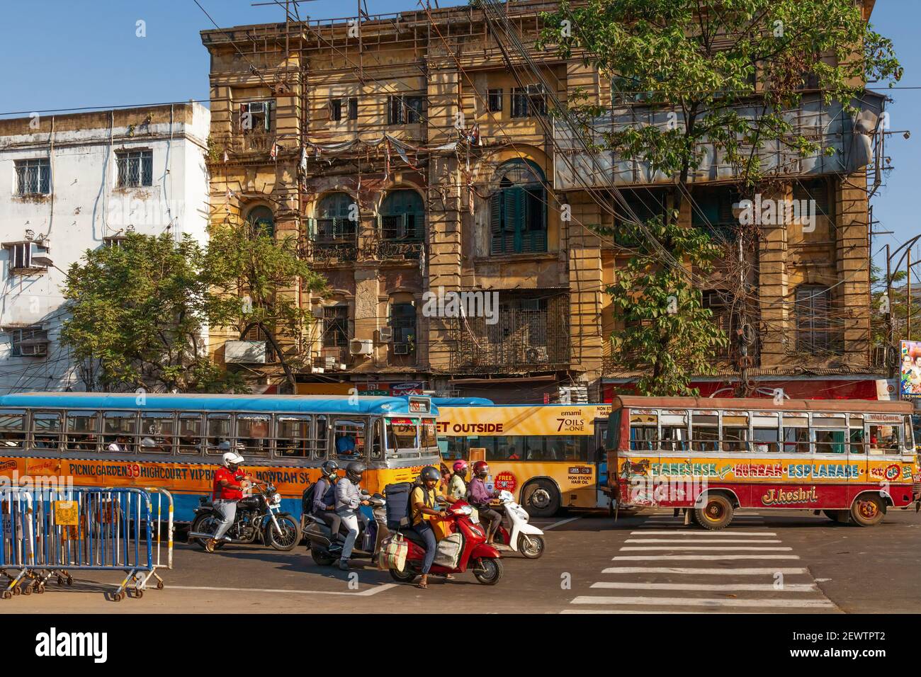 Mezzi di trasporto pubblico con pendolari al passaggio della strada cittadina Vecchi edifici storici a Esplanade Kolkata Foto Stock