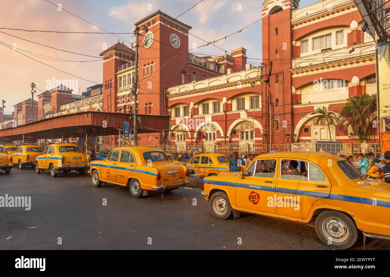 Taxi giallo in coda alla stazione ferroviaria di Howrah, un popolare punto di riferimento della città a Kolkata, India all'alba. Foto Stock