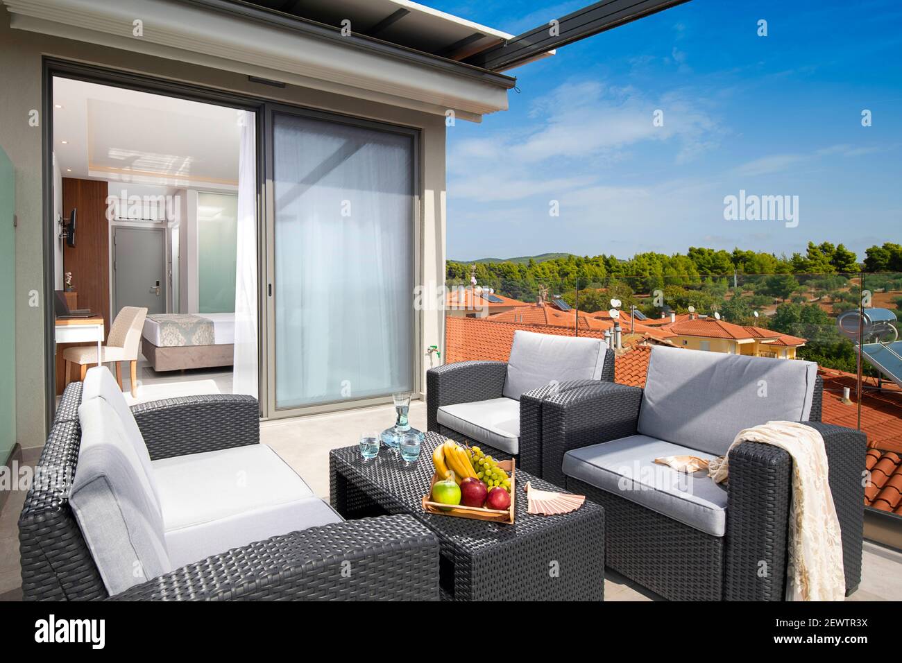Vista panoramica estiva del tetto terrazza aperta con vimini Arredamento in moderno appartamento monolocale di un resort europeo Foto Stock