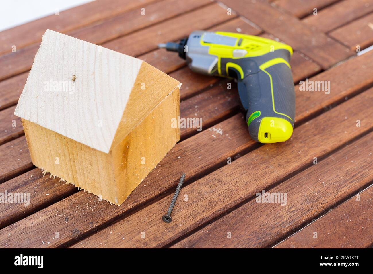 Sul tavolo è presente un moderno utensile di lavoro miniaturizzato per viti avvitatrici. Artigianato da barre di legno. Foto Stock