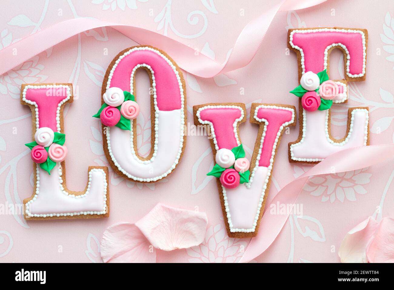 I biscotti decorati di San Valentino che compongono la parola amore Foto Stock