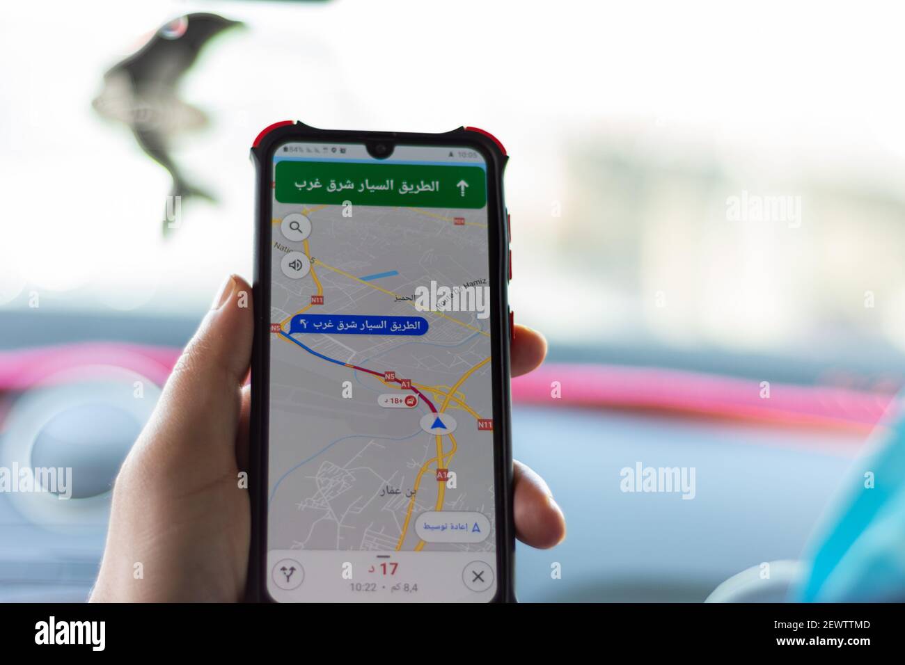 Primo piano con la mano maschile che tiene lo smartphone utilizzando l'app Maps Foto Stock