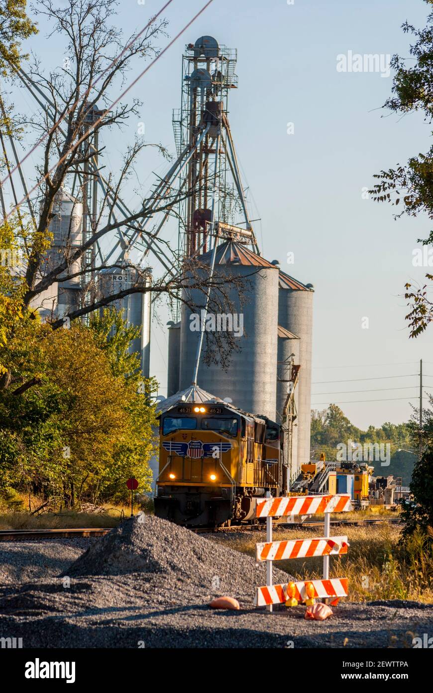 Treno di trasporto degli Stati Uniti in Illinois rurale con i silos di grano in sfondo Foto Stock