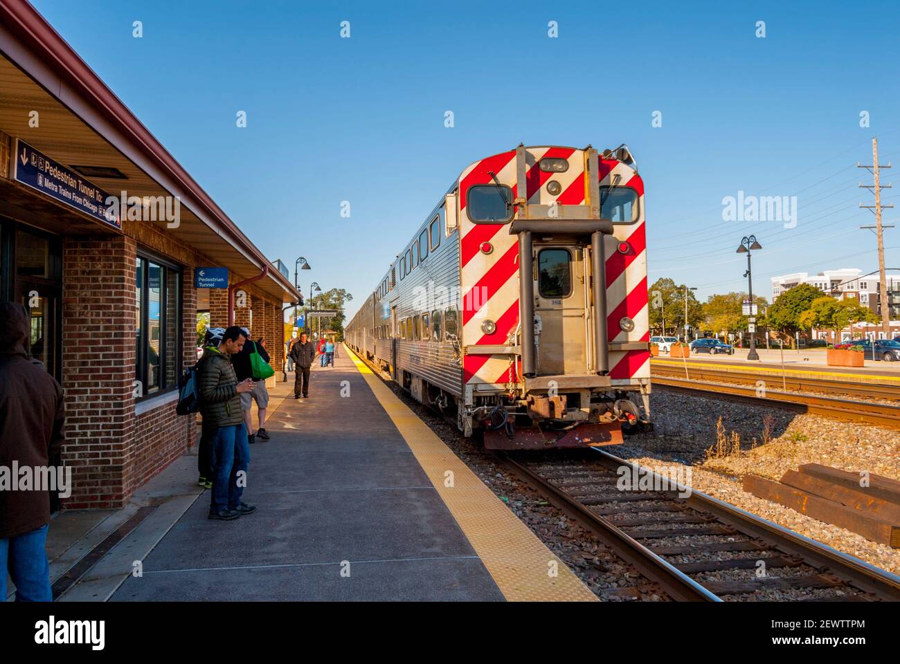 Piattaforma della stazione ferroviaria a Lisle, Illinois, in una giornata di sole con treno passeggeri in piattaforma Foto Stock