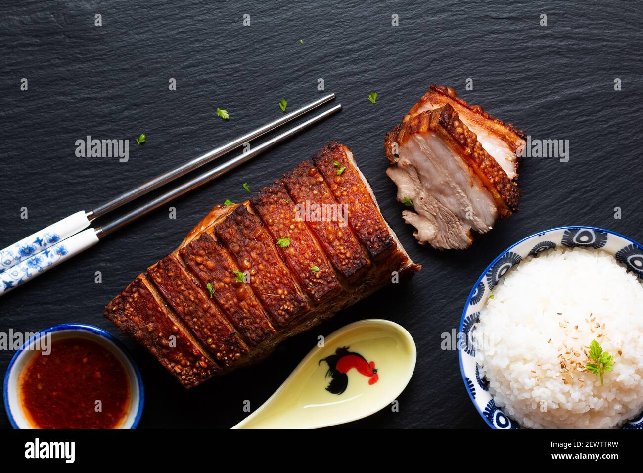 Il concetto di cibo focalizza la pancia di maiale croccante cotta in casa asse di pietra ardesia nero con spazio di copia Foto Stock