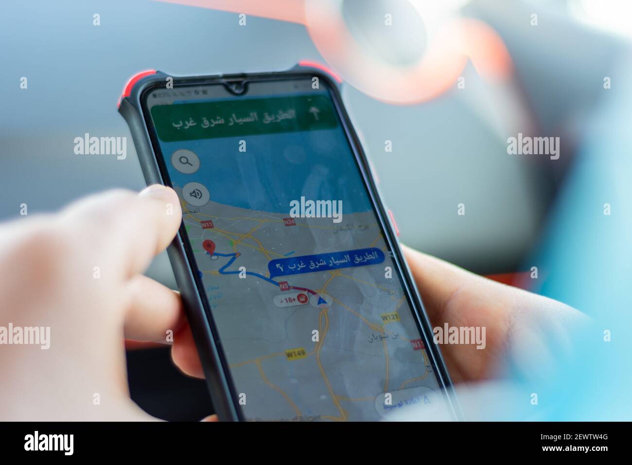 Primo piano con la mano maschile che tiene lo smartphone utilizzando l'app Maps Foto Stock