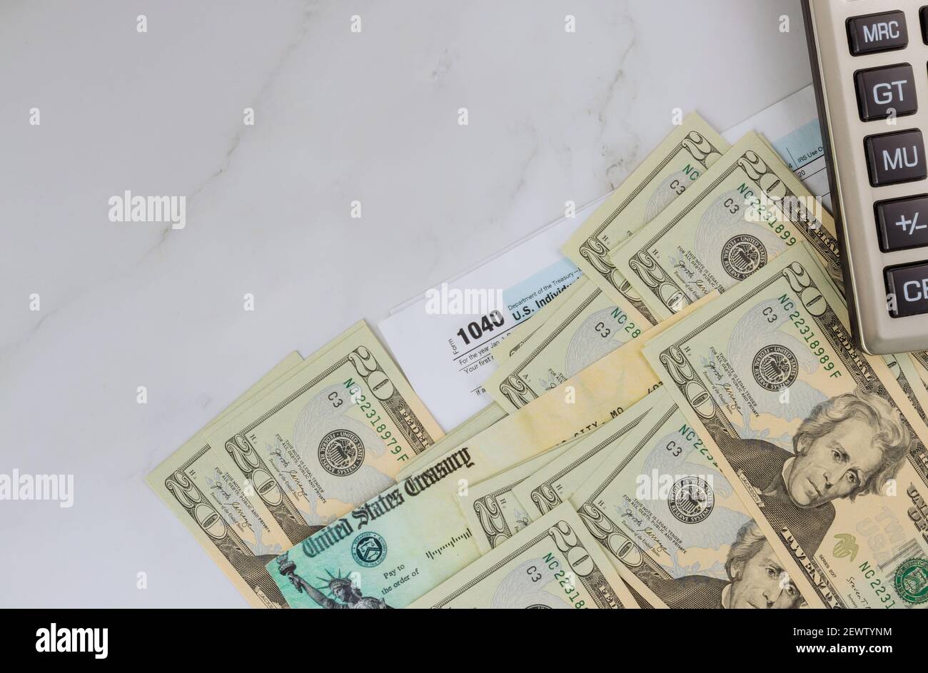 Closeup 1040 forma fiscale con assegno di rimborso e la valuta US dollar banconote Foto Stock
