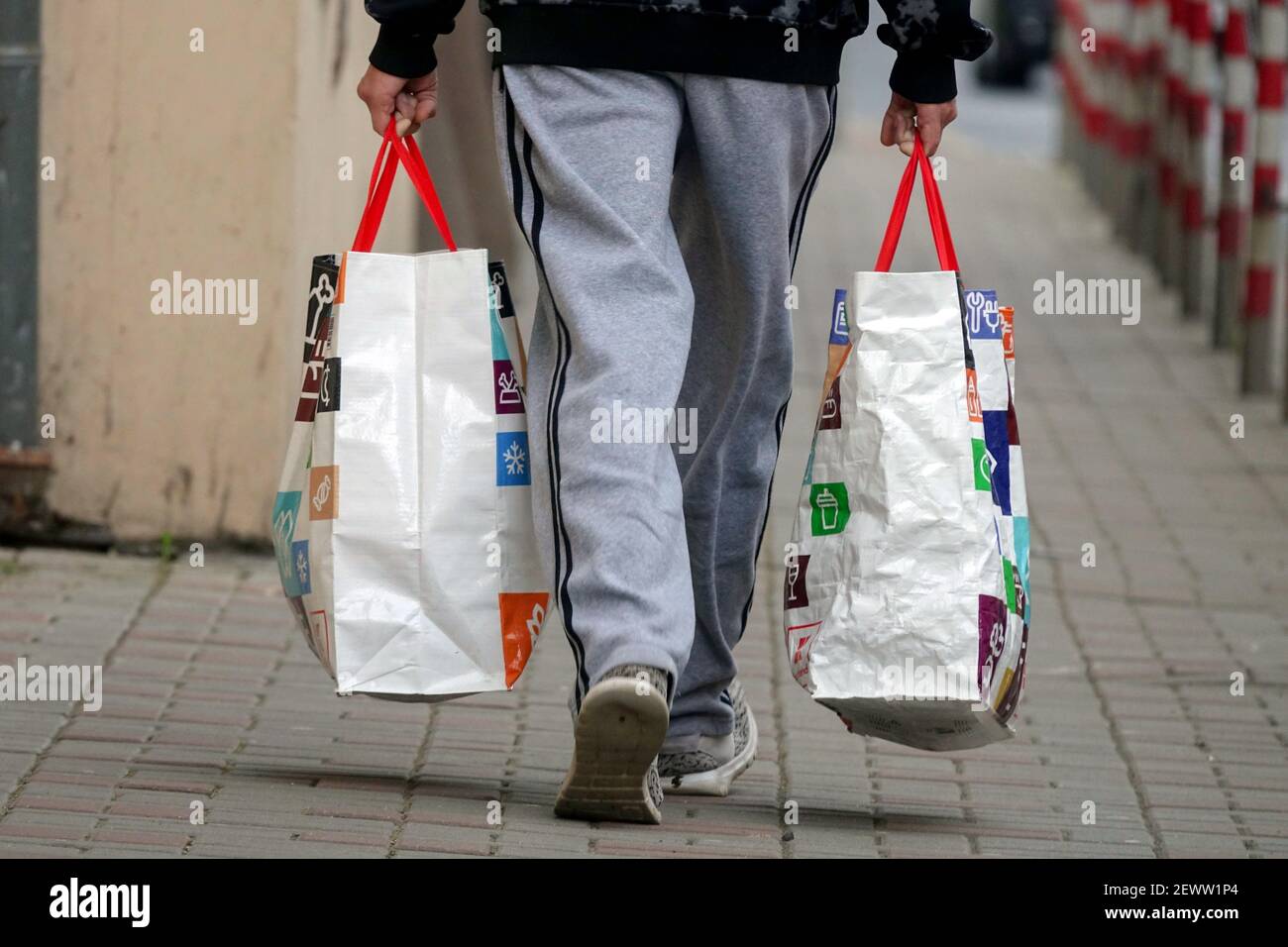 L'uomo porta due borse del supermercato, l'uomo se ne va Foto Stock